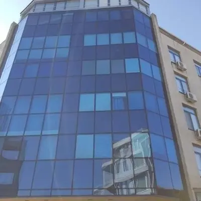 a tall blue glass building with a balcony at Rainbow 1 in Sunny Beach