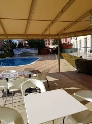 a patio with white tables and chairs and a pool at Rainbow 1 in Sunny Beach
