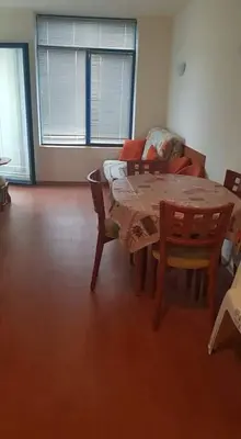 a dining room with a table and chairs and a couch at Rainbow 1 in Sunny Beach