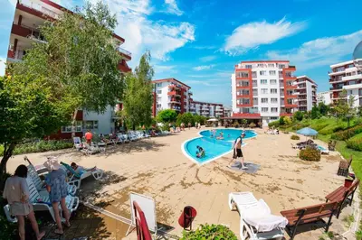 a group of people sitting around a swimming pool at Marina View Fort Beach in Sveti Vlas