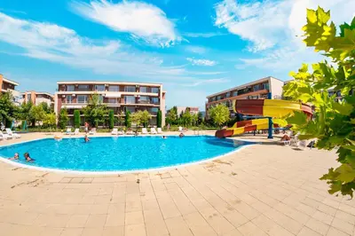 a large swimming pool in a courtyard with buildings at Orchid Fort Garden in Sunny Beach
