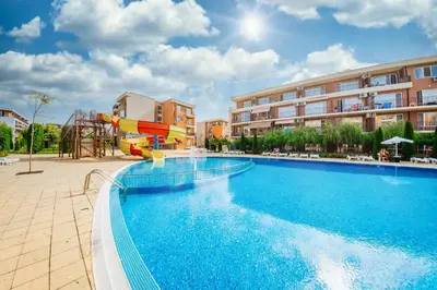 a swimming pool with a slide in front of a building at Orchid Fort Garden in Sunny Beach