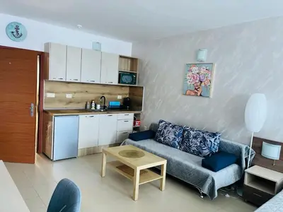 a living room with a couch and a kitchen at ESPERANTO 403 Large Studio Sunny Beach in Sunny Beach