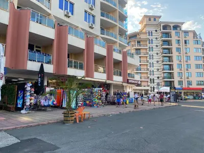 a city street with a building and people walking on the sidewalk at ESPERANTO 403 Large Studio Sunny Beach in Sunny Beach