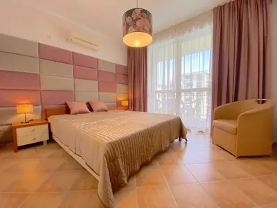 a bedroom with a bed and a chair and a window at Cascadas Family Resort - Private apartment - BSR in Sunny Beach