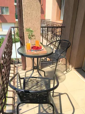 a table and chairs on a balcony with a plate of fruit at Стаи за гости Димитрови in Burgas City