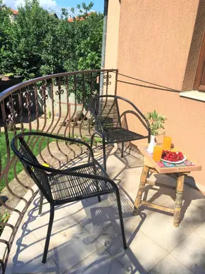 two black chairs and a table on a balcony at Стаи за гости Димитрови in Burgas City