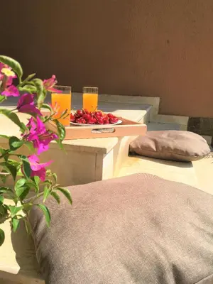 a table with glasses of orange juice and a plate of fruit at Стаи за гости Димитрови in Burgas City