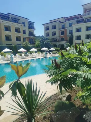 a pool with chairs and umbrellas in a resort at Lily Beach - Apartment 408A in Sozopol