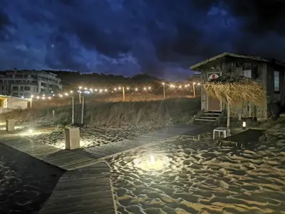 a wooden dock on the beach at night at Lily Beach - Apartment 408A in Sozopol
