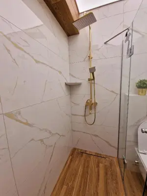 a bathroom with white marble walls and a shower at FS Apartments Varna - Beautiful apartment in the center of Varna in Varna City