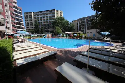 a large swimming pool with benches and umbrellas at Menada Admiral Plaza Apartaments in Sunny Beach