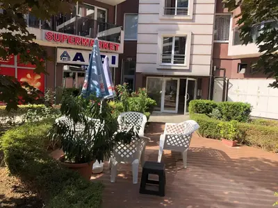 two chairs and a table in front of a building at Menada Admiral Plaza Apartaments in Sunny Beach
