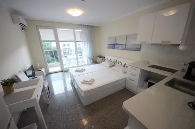 a small room with a bed and a kitchen at Menada Admiral Plaza Apartaments in Sunny Beach