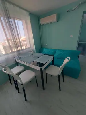 a room with a table and chairs and a couch at Апартамент Холи in Sozopol