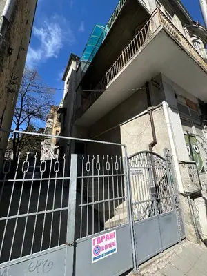 a fence in front of a building with a sign on it at Home in Varna City
