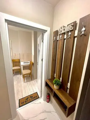 a hallway with a mirror and a room with a table at Home in Varna City