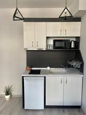 a kitchen with white cabinets and a sink and a microwave at Dream in Varna City