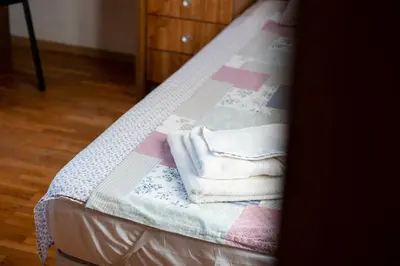 a bed with a stack of towels on it at Roman Thermae 2bdrm Sunny Apartment in Varna City