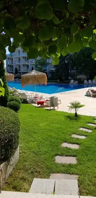 a resort with a swimming pool and a grassy yard at Apartment with green terrace in Burgas City