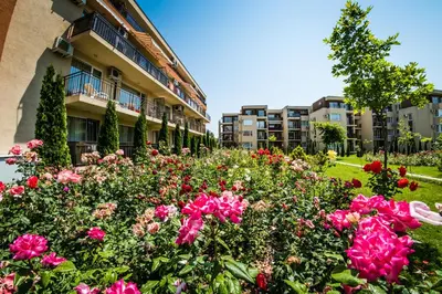 a garden of flowers in front of a building at Holiday Garden Resort in Sunny Beach