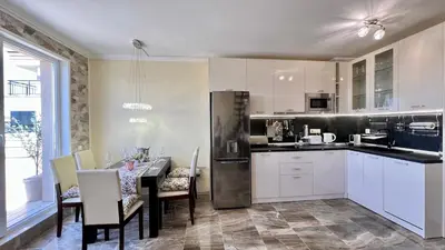 a kitchen with white cabinets and a table with chairs at Bratanov Vip Zone maisonettes 606 & 609 in Sunny Beach