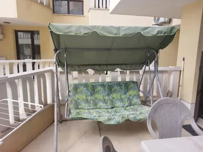 a green chair sitting on a balcony at Studio Sarafovo in Burgas City