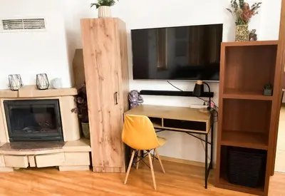 a room with a desk and a television and a desk with a chair at Two Bedroom Apartment - Alexandrovska - Top Location - Central Bus, Train and Marine Stations, next to Sea Garden and Beach in Burgas City