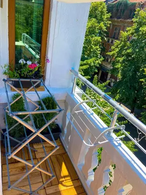 a balcony with a plant holder and a window at Two Bedroom Apartment - Alexandrovska - Top Location - Central Bus, Train and Marine Stations, next to Sea Garden and Beach in Burgas City