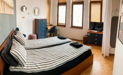 a bedroom with a large bed and a television at Two Bedroom Apartment - Alexandrovska - Top Location - Central Bus, Train and Marine Stations, next to Sea Garden and Beach in Burgas City