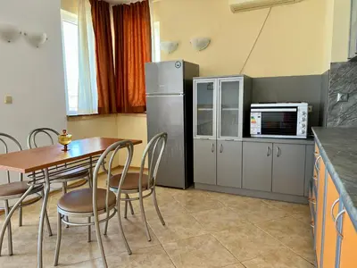 a kitchen with a table and chairs and a refrigerator at Private One-Bedroom Apartment with Balcony in Sozopol by Flat Mаnаger in Sozopol