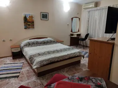 a bedroom with a bed and a desk and a television at Kamelya Guest Studio in Nesebar