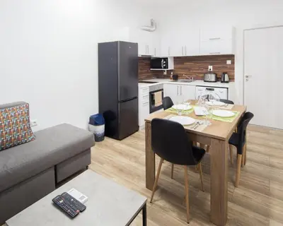a kitchen and dining room with a table and a couch at Aleks Sunrise -Top Center ,Sea Garden in Burgas City