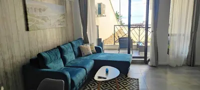 a living room with a blue couch and a table at Antique 7 ap.1 in Sozopol
