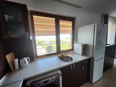 a kitchen with a sink and a refrigerator and a window at Famagusta Antoniya in Aheloy
