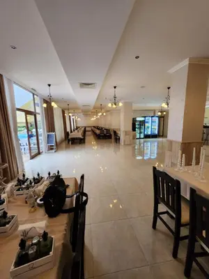 a large lobby with tables and chairs in a building at Famagusta Antoniya in Aheloy