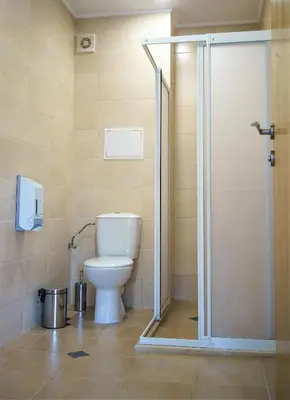 a bathroom with a toilet and a glass shower stall at Moreto Seaside Aparthotel in Obzor