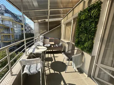 a balcony with chairs and tables on a building at Luxury Apartments Ani in Burgas City