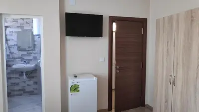 a bathroom with a sink and a television on a wall at Къща за гости Снежа/ Guest house Snezha in Obzor