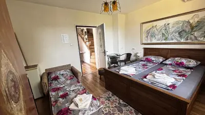 a bedroom with two beds and a table in it at Guest house Hei taka in Sozopol