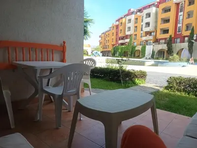a table and chairs on a patio with a view of a street at APARTMENT DELUXE MARINA CAPE 4 stars complex 33 6 in Aheloy