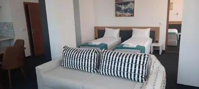 a living room with two beds and a couch at Къща за гости Вивиан in Kiten