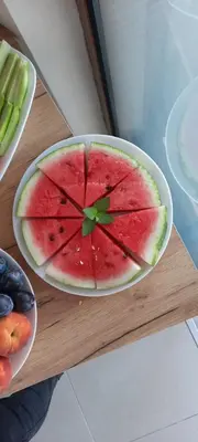 a slice of watermelon in a bowl on a table at Къща за гости Вивиан in Kiten