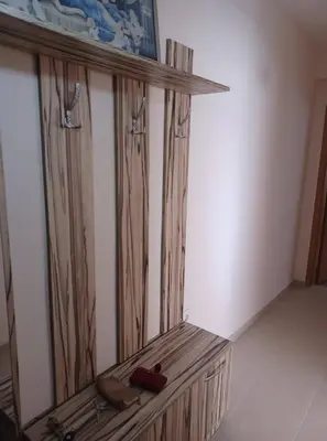 a wooden bench in a room with a mirror at Апартамент Желева in Pomorie