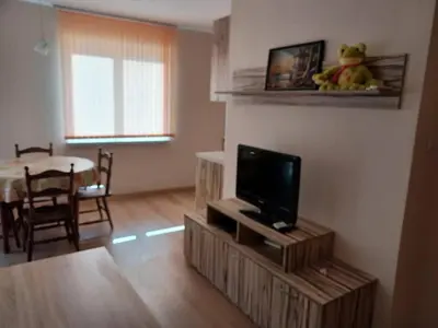 a living room with a flat screen tv on a stand at Апартамент Желева in Pomorie