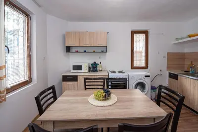 a kitchen with a table with a bowl of fruit on it at Къща за гости Димови in Sozopol