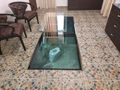 a living room with a glass table on a tiled floor at Къщата с разкопките - The house with the excavations in Sozopol