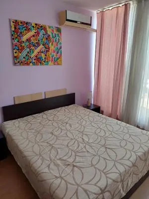 a bedroom with a bed and a painting on the wall at Gradina Sunny Deluxe apartment in Sozopol