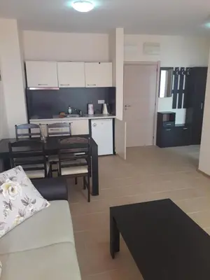 a living room with a couch and a table and a kitchen at Gradina Sunny Deluxe apartment in Sozopol