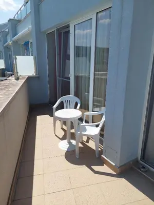 a patio with two chairs and a table on a balcony at Gradina Sunny Deluxe apartment in Sozopol